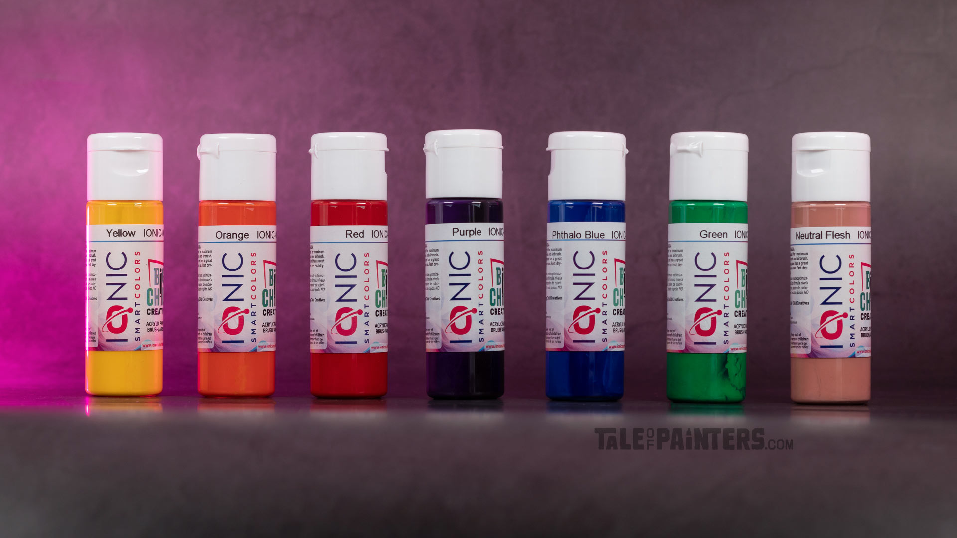 Seven bottles of Ionic Smart Colors lined up on a concrete background with pink light, photographed for a review of the Ionic Smart Colors range