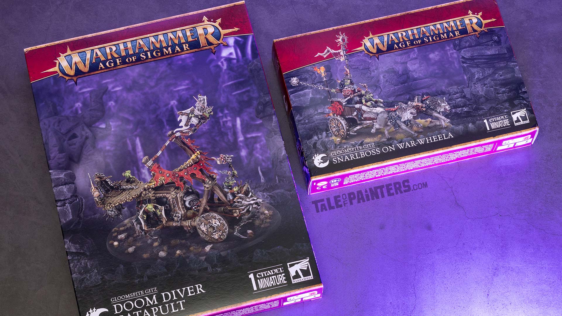 Gloomspite Gitz Doom Diver Catapult and Snarlboss on War-wheela boxes arranged on a concrete background with purple light, photographed for an unboxing and review