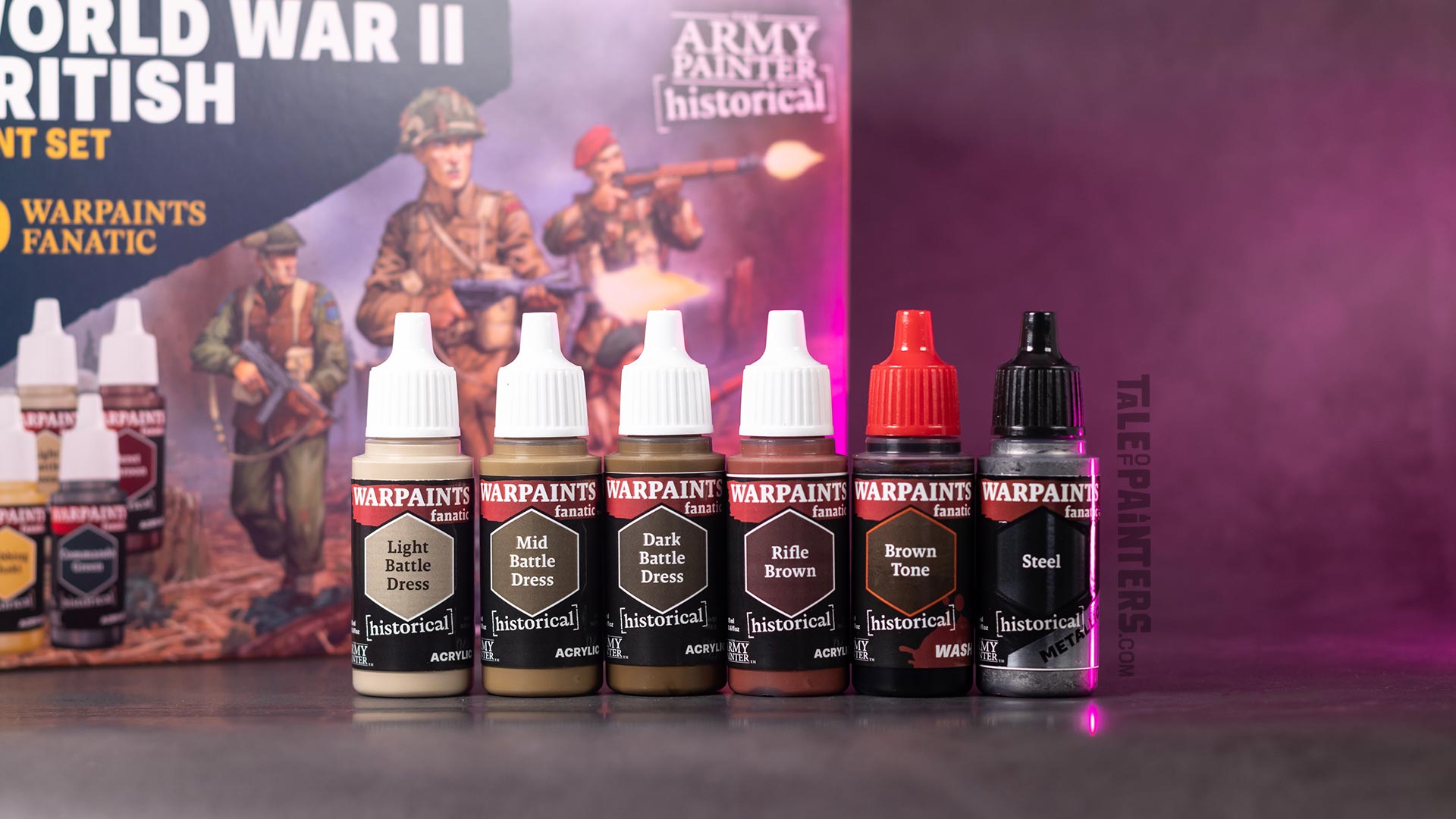 Six Warpaints Fanatic bottle from the Historicals rang lined up in front of the British World War II paint set box, lit with pink light, photographed for review purposes