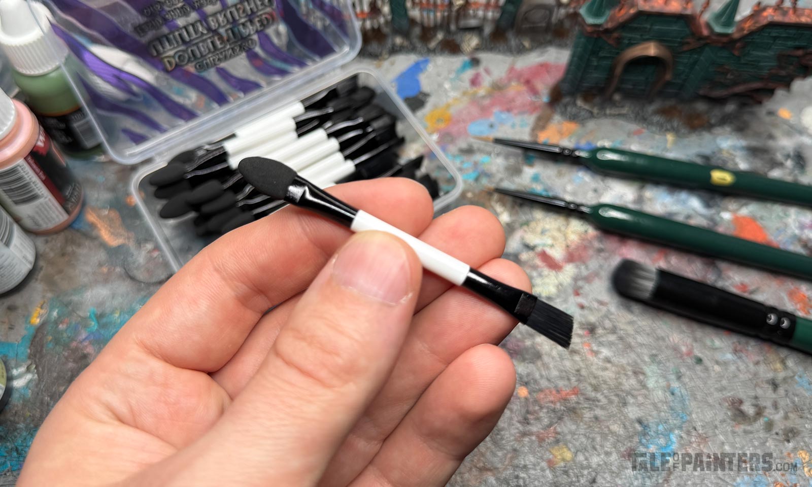 Hand holding a double-sided utility brush from Chroncile