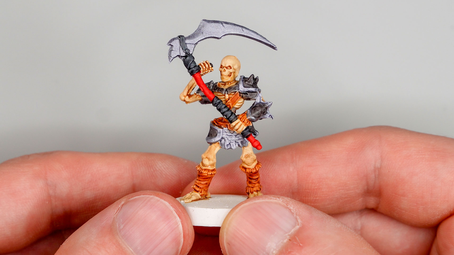 Two hands holding a Heroquest Skeleton Warrior painted with Speedpaint markers from The Army Painter
