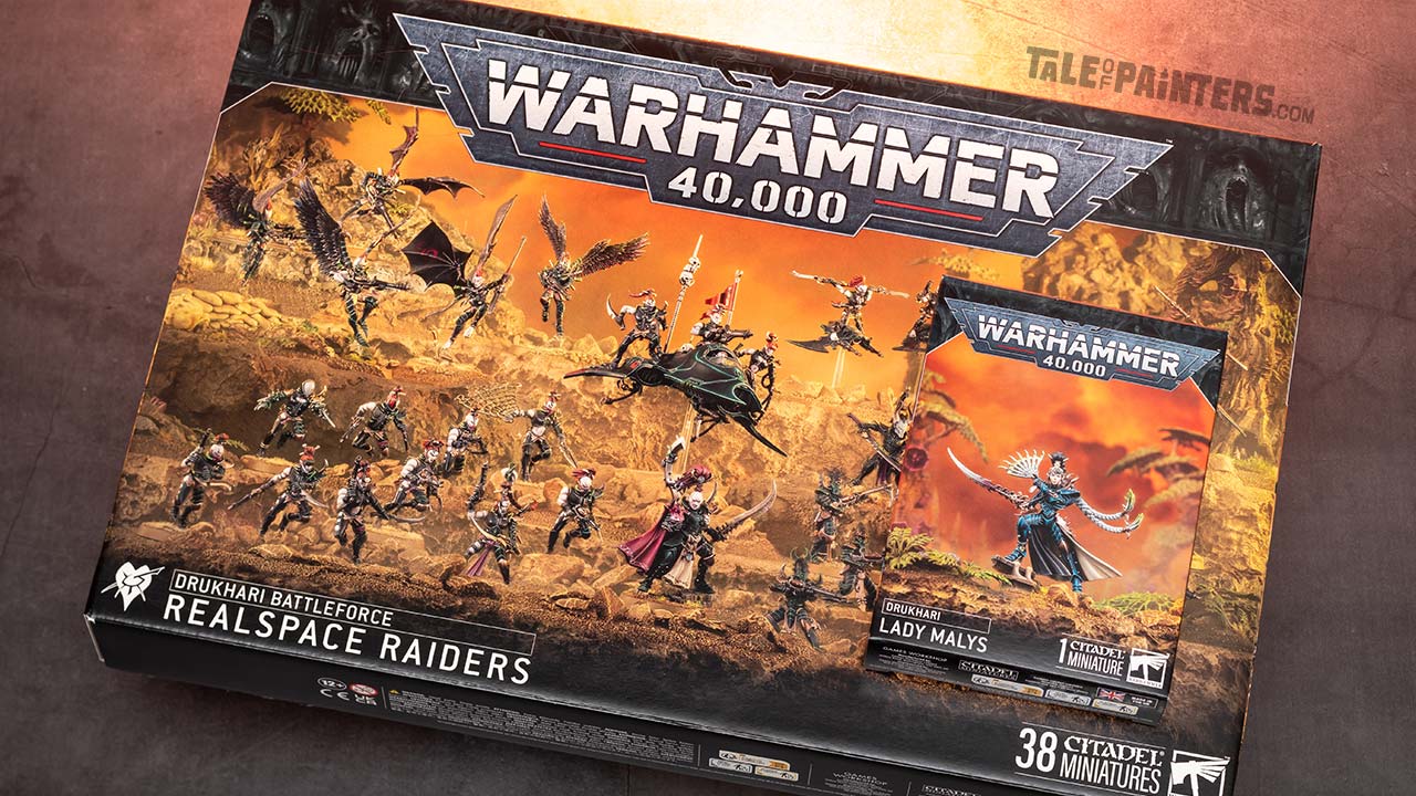 Drukhari Realspace Raiders Battleforce and Lady Malys boxes arranged on a concrete background, lit with orange light, photographed for review purposes