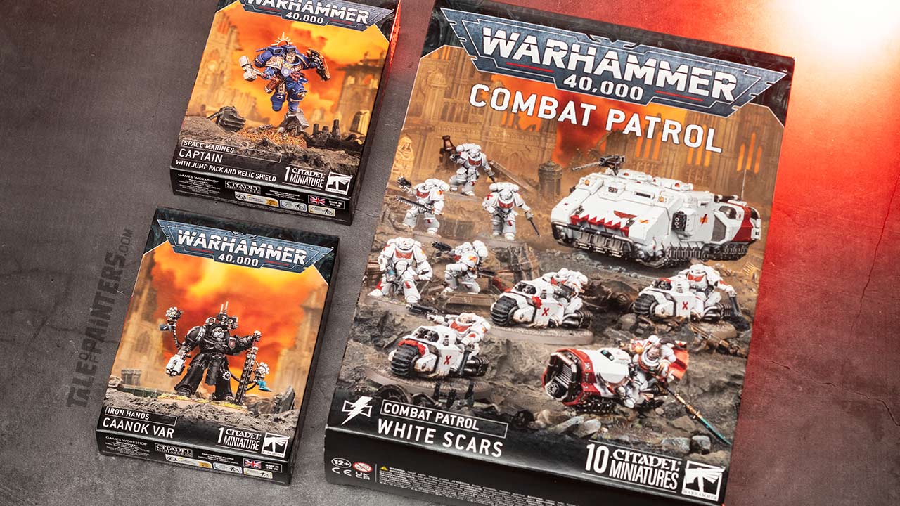 Space Marines Captain with Jump Pack and Relic Shield, Iron Hands Caanok Var, and White Scars Combat Patrol boxes arranged on a concrete background, photographed for review purposes