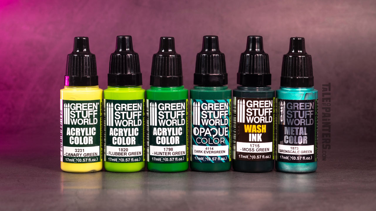 A selection of six green paint bottles from Green Stuff World, with Maxx Formula, Opaque, Metal Colors, and a Wash, concrete background, lit with pink light, photographed for a review