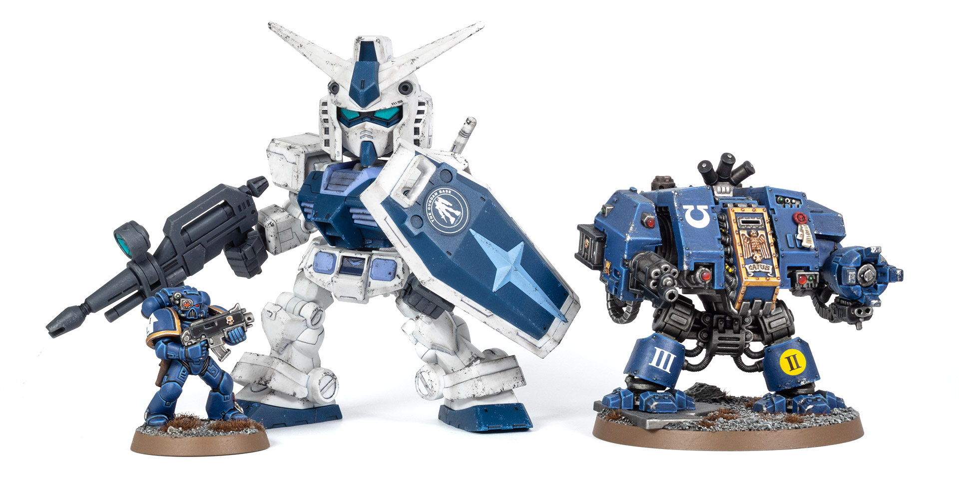 A Firstborn Ultramarine and Dreadnought next to an RX-78-2 Gundam SD Cross Silhouette in Limited Gundam Base blue colours, on a white background