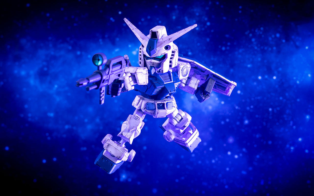 Cinematic shot of a weathered RX-78-2 Gundam SD Cross Silhouette in Limited Gundam Base monochrome blue, floating in attack pose in front of a dramatic blue space background