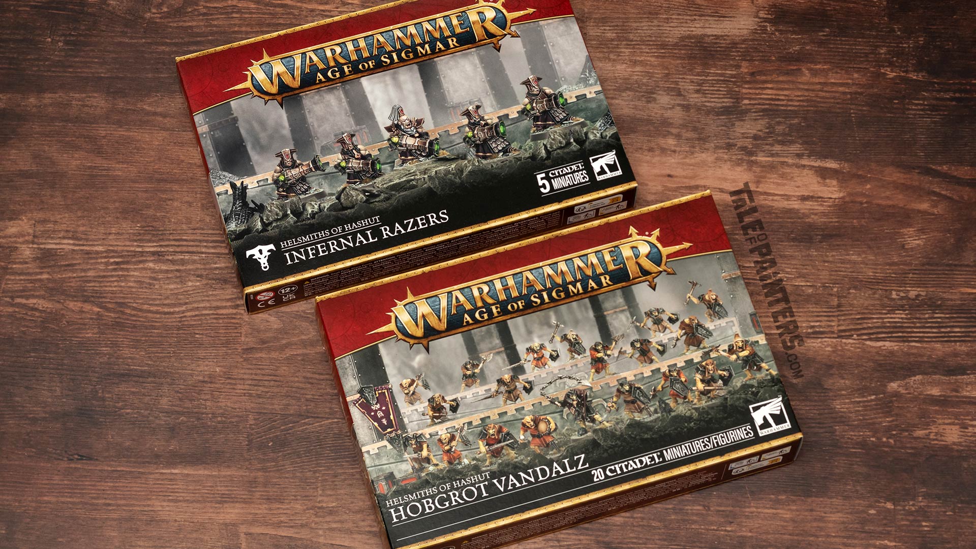 Helsmiths of Hashut Infernal Razers and Hobgrot Vandalz boxes arranged on a wooden background, photographed for review purposes