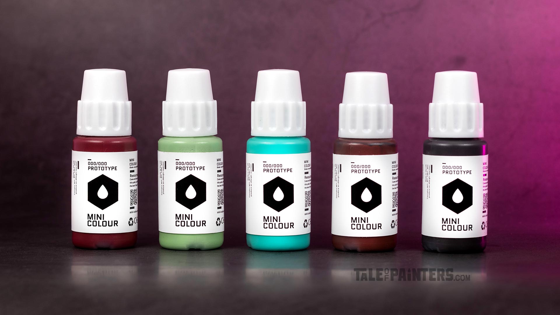 Five prototype Mini Colour bottles arranged in a line, in front of a pink lit concrete background