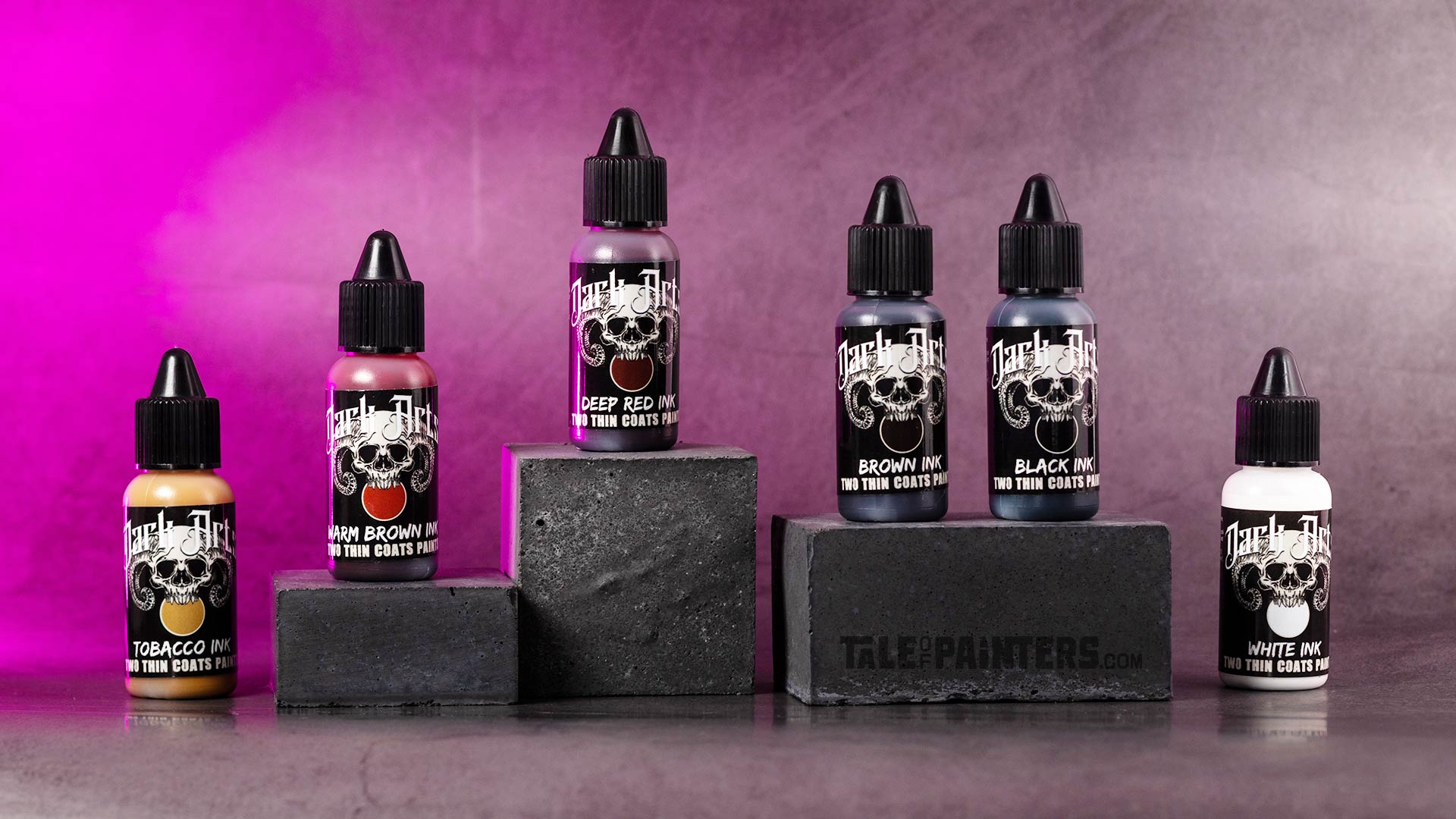 The five Two Thin Coats Dark Arts Ink bottles arranged on concrete blocks on a pink lit concrete background