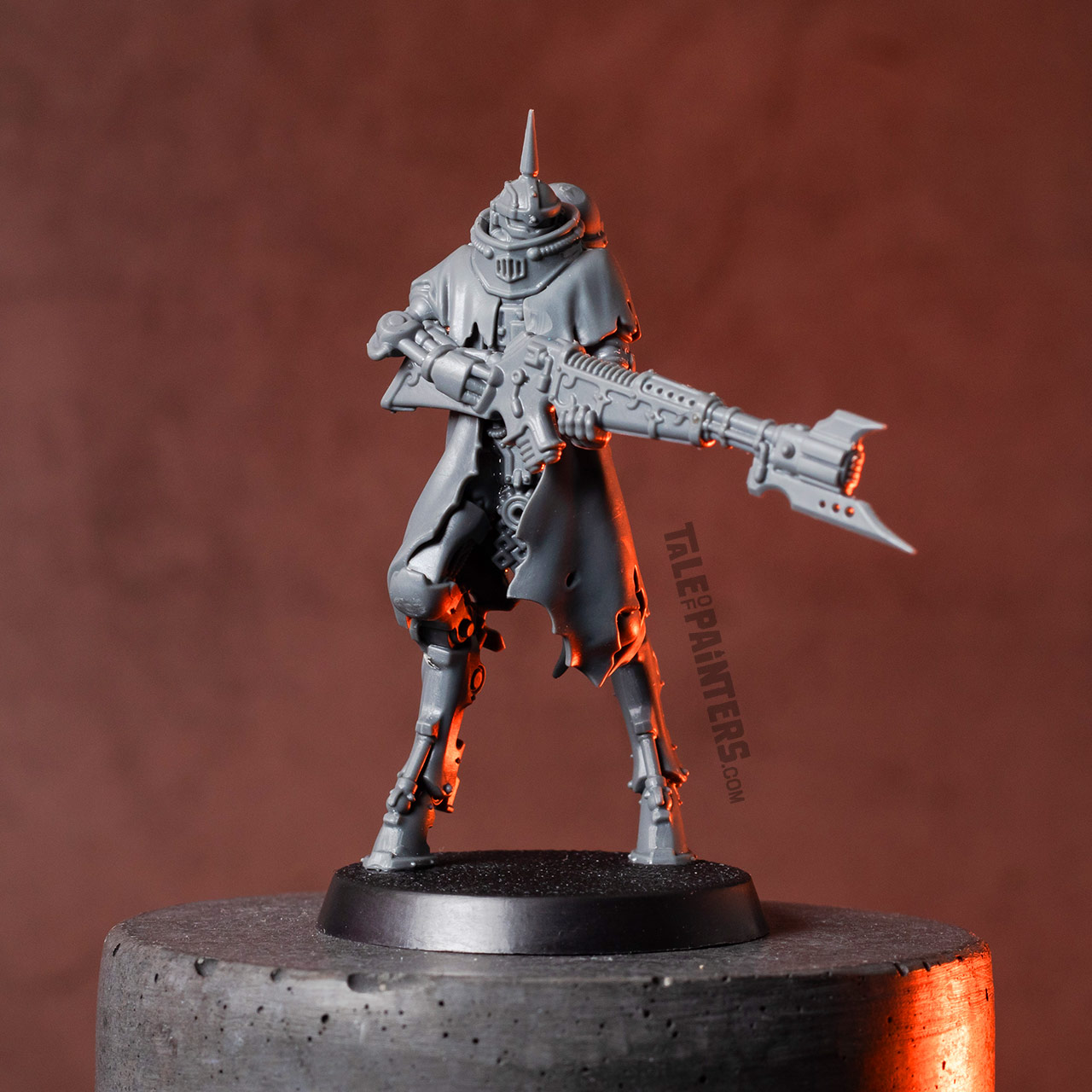 Stylised shot of a Skitarii Battle-Pilgrym model, unpainted, on a concrete plinth, lit with orange light