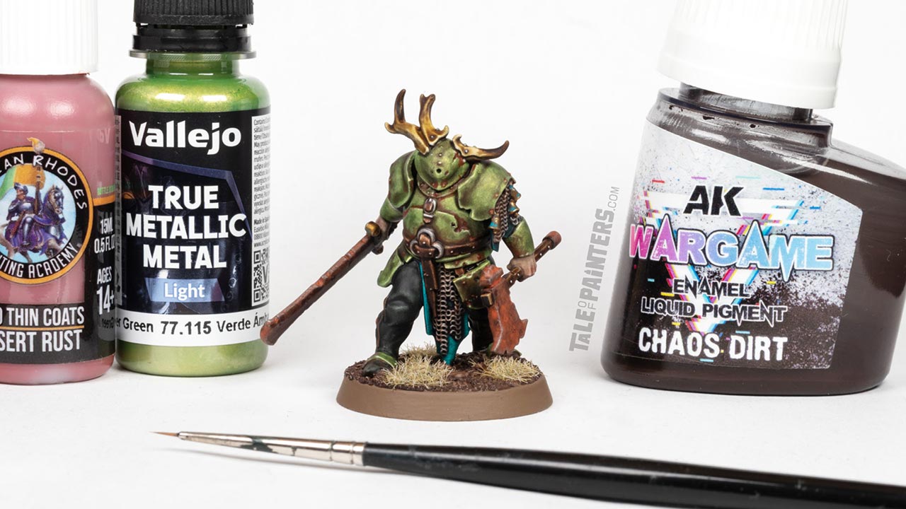 A Maggotkin of Nurgle Rotsword model, painted by Stahly, surrounded by AK, Vallejo and Two Thin Coats paint bottles, arranged for a painting tutorial