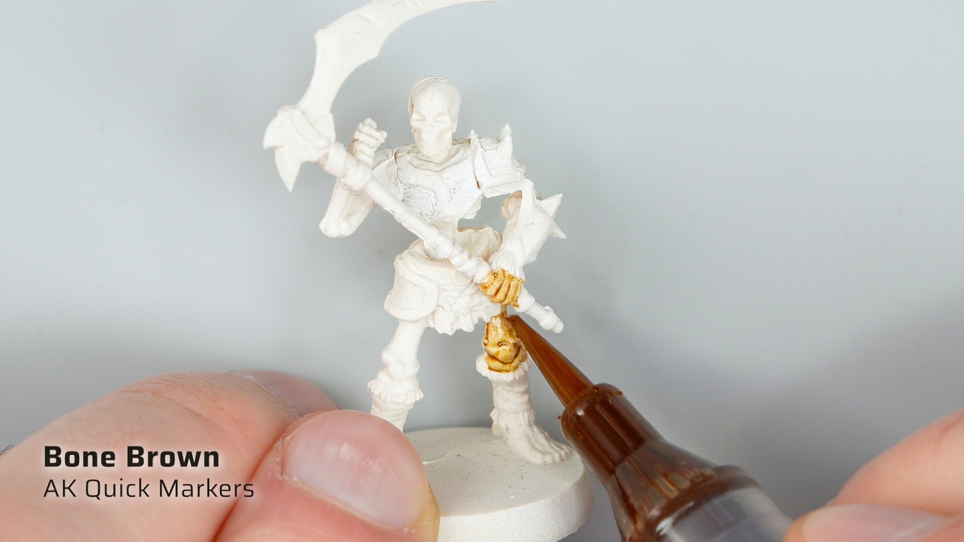 Close up of applying Quick Gen Bone Brown paint with an AK Quick Marker on a white primed Heroquest Skeleton Warrior model