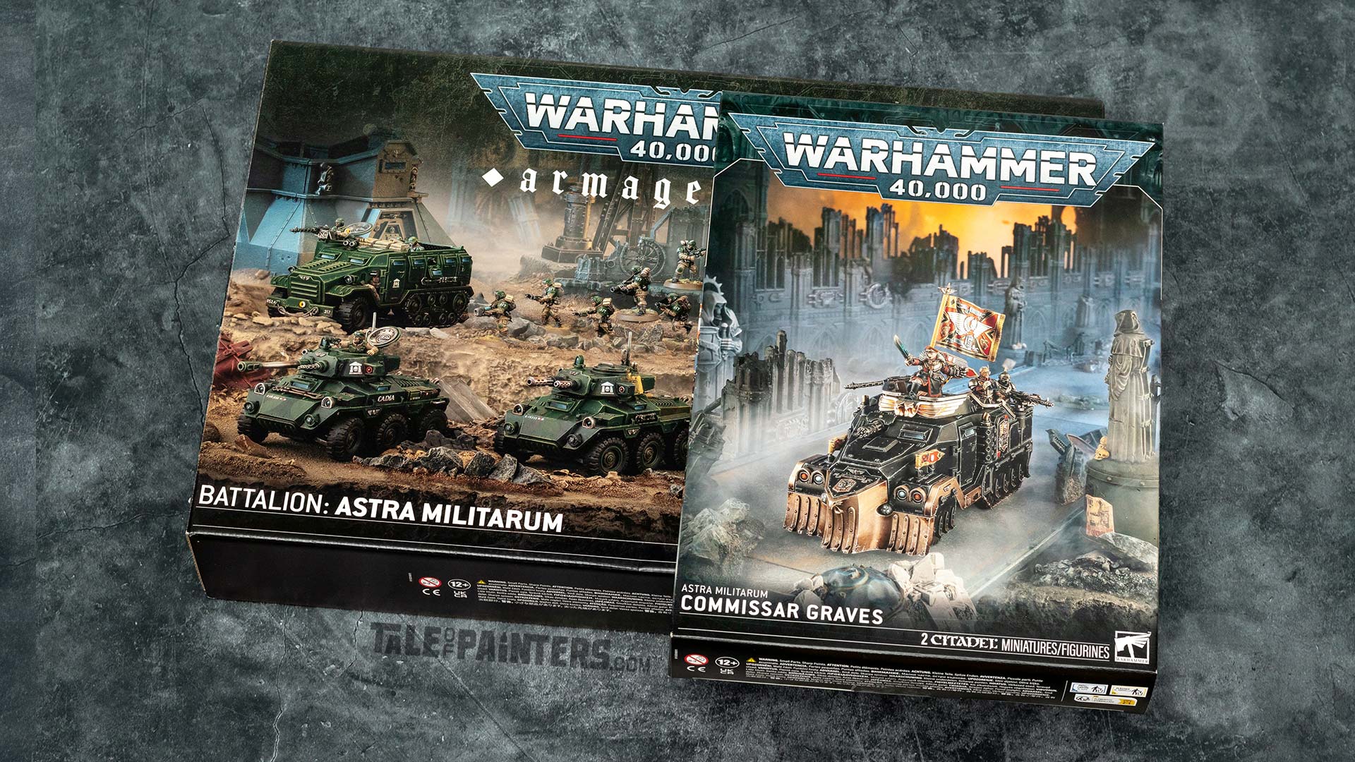 Batallion: Astra Militarum Armageddon and Commissar Graves model kit boxes, arranged on a concrete background, photographed for an unboxing an review