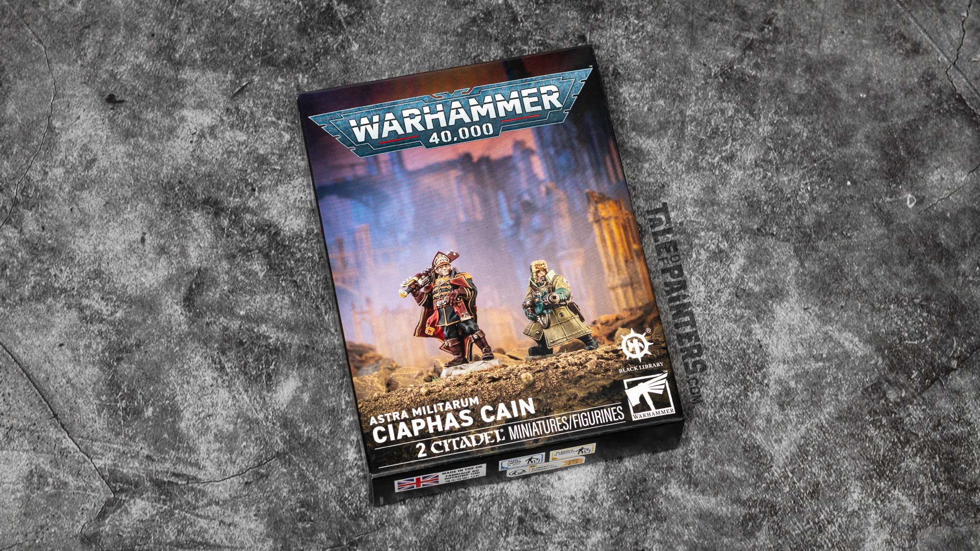 Ciaphas Cain and Jurgen model box for Warhammer 40,000, arranged on a concrete background for a review and unboxing