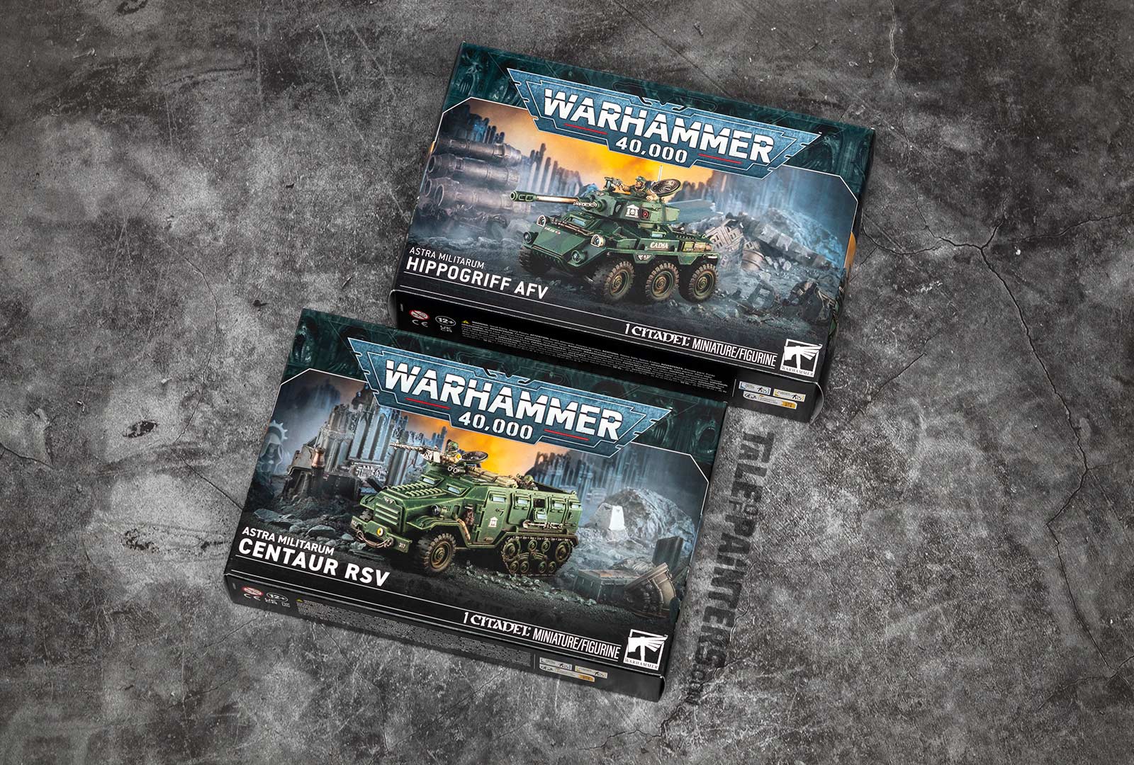 Astra Militarum Hippogriff AFV and Centaur RSV model boxes for Warhammer 40,000, arranged on a concrete background for a review and unboxing
